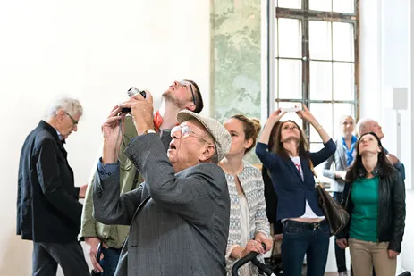 Besucherinnen und Besucher fotografieren das Deckenfresko im Steinernen Saal