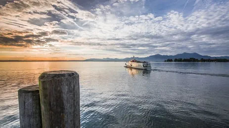 Ein Schiff auf dem Chiemsee vor Alpenkulisse.
