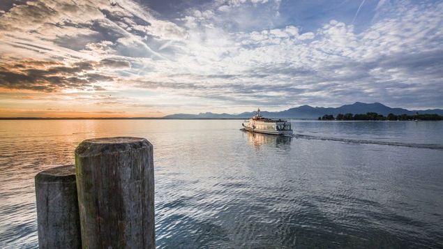 A boat on Chiemsee in front of an Alpine backdrop.