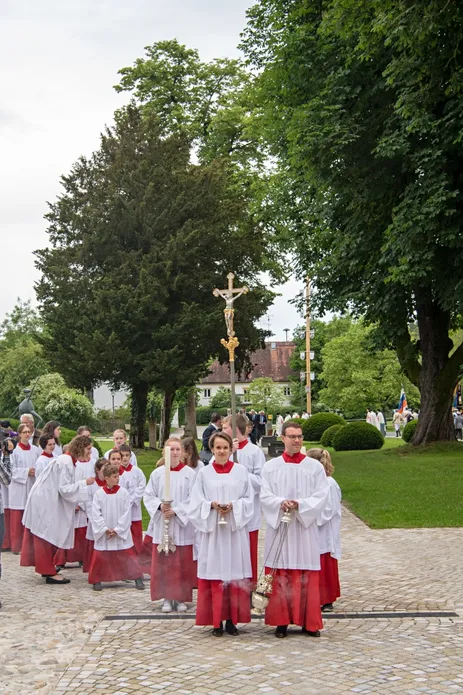 Ministrantinnen und Ministranten mit liturgischen Utensilien stellen sich zum Einzug auf