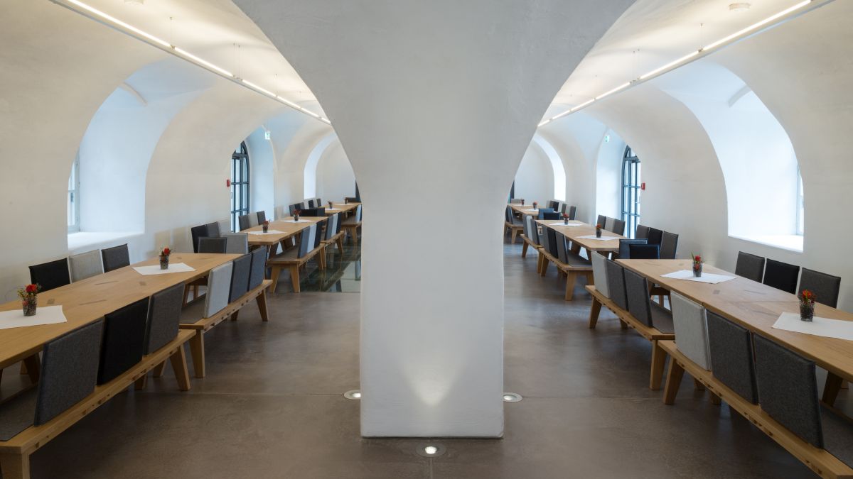 Tables and benches with space for 112 people in the vaulted hall at the TUM Science and Study Center Raitenhaslach.